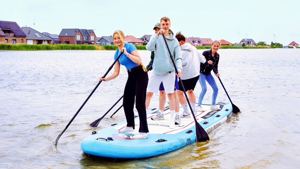 Schüler mit einem Stand Up Paddle auf dem See
